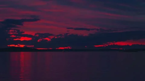 Vibrant dark red sunset dusk sky clouds flying over water aerial view Stock Footage 276659758