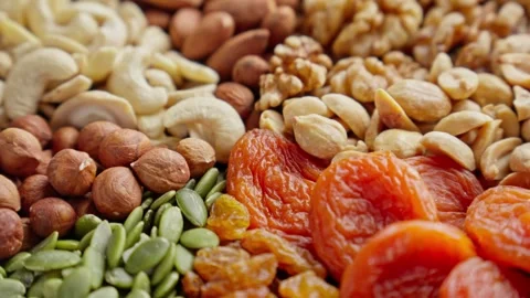 Vibrant display of almonds, cashews, walnuts, and dried apricots fills surface 스톡 동영상 294916473