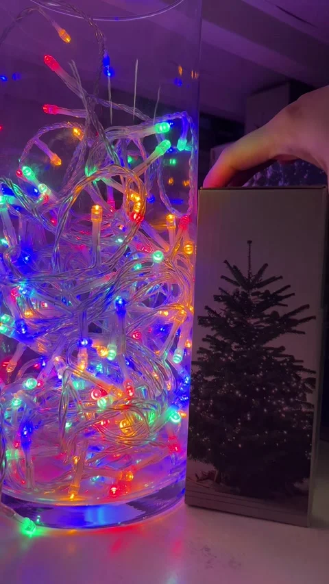 A vibrant display of colorful Christmas string lights placed in a glass vase Stock Footage 293641671