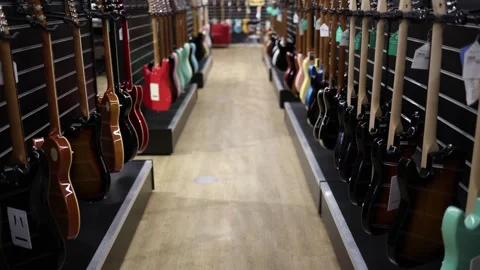 A vibrant display of electric guitars in various colors and finishes lining both Stock Footage 294706698