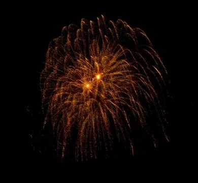 A vibrant display of golden fireworks exploding in a spider-like pattern ag.. Stock Photos