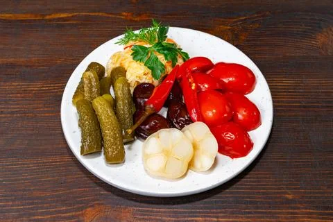 A vibrant display of pickled vegetables featuring green cucumbers, red pepper Stock Photos