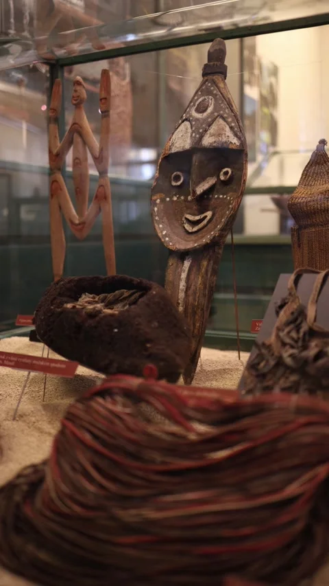 A vibrant display of traditional artifacts, including carved masks, woven basket Stock Footage 293467138