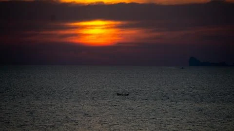 Vibrant dramatic orange sunset, dark water in Koh Lanta, Thailand Stock Photos