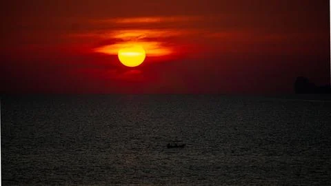 Vibrant dramatic orange sunset, dark water in Koh Lanta, Thailand Stock Photos