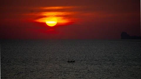 Vibrant dramatic orange sunset, dark water in Koh Lanta, Thailand 스톡 사진