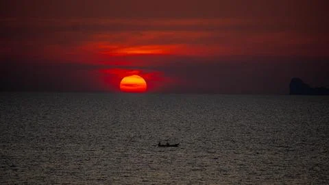 Vibrant dramatic orange sunset, dark water in Koh Lanta, Thailand Stock-Fotos