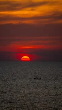 Vibrant dramatic orange sunset, dark water in Koh Lanta, Thailand Stock Photos