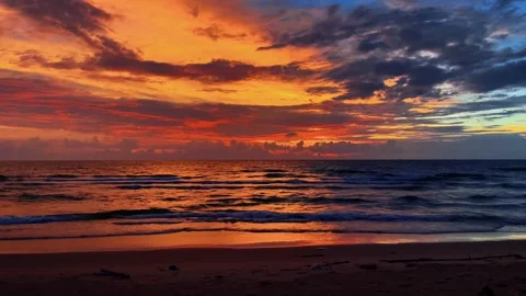 Vibrant Dramatic Sunset with Fiery Clouds Over Rolling Ocean Waves Stock Footage 331785663