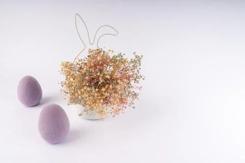 Vibrant Easter composition with two fuzzy purple eggs, colorful dried flowe.. Stock Photos