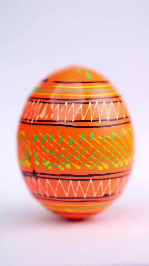 A vibrant Easter egg rotates on a white background, showcasing bold colors .. Stock Footage 297682986