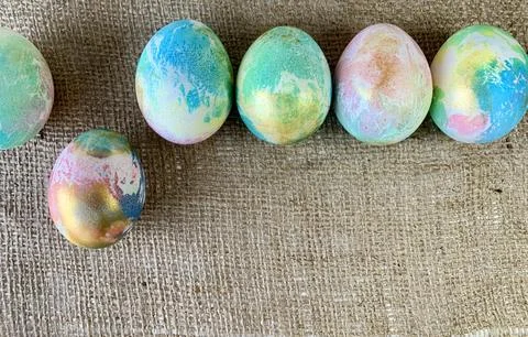 Vibrant Easter eggs showcase a marbled design, placed neatly in a row on a Stock Photos