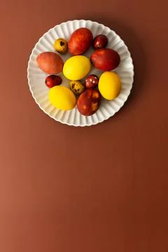 Vibrant Easter eggs in various colors rest on a white plate, showcasing sha.. Stock Photos