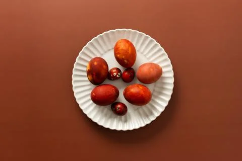Vibrant Easter eggs in various shades of red and orange are beautifully arran Stock Photos