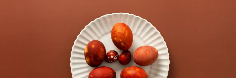 Vibrant Easter eggs in various shades of red and orange are beautifully arran 库存照片