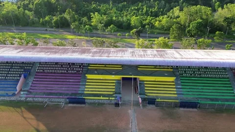Vibrant empty stadium seating overlooks a rustic outdoor sports field amids.. 스톡 동영상 325281395