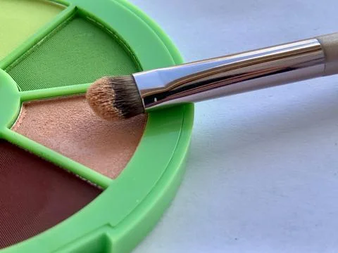 A vibrant eyeshadow palette features multiple shades, including green, brown, Stock Photos