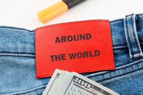 A vibrant fabric patch reads Around the World, attached to denim. Nearby, a s Stock Photos