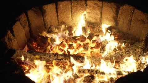 A vibrant fire with flames licking at logs and glowing coals burns brightly.. Stock Footage 306733073