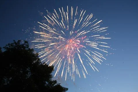 Vibrant firework explosion radiating sparks in the evening sky Фото