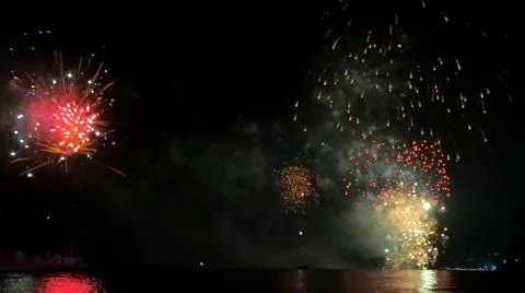 Vibrant fireworks explode across the dark night sky showcasing brilliant re.. Stock Photos