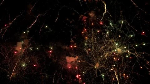 Vibrant fireworks exploding across dark night sky with golden sparks, colorful Stock Photos
