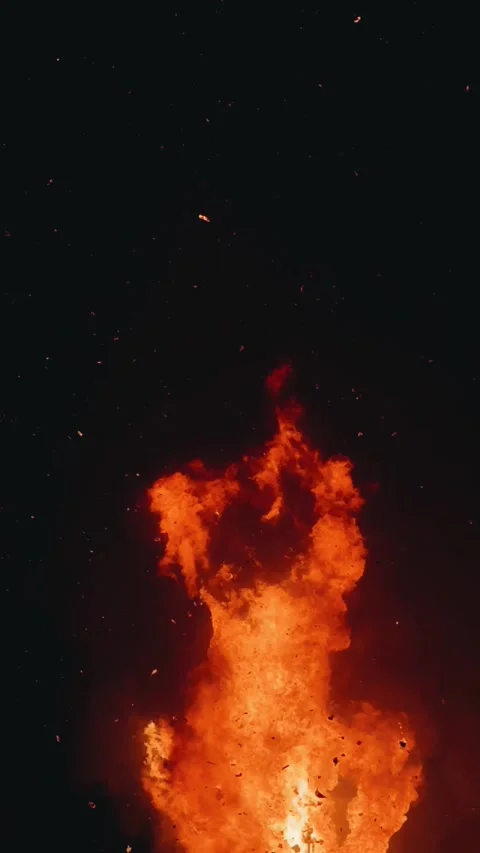 Vibrant Flames Dance Against Dark Night Sky in Vertical Cinematic Fire Clip Stock Footage 345808374