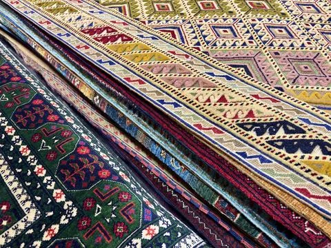 Vibrant geometric patterns on Central Asian folded carpets. Stock Photos