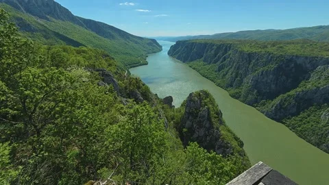 Vibrant green cliffs surround winding river below. Balkan, Eastern Europe, POV 스톡 동영상 333348431