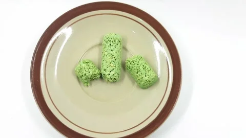 Vibrant green crispy rice snacks on plate footage Video stock 331864206