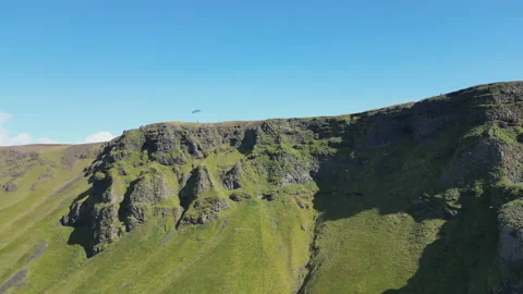 Vibrant green mountain slopes and jagged rocky cliffs in Iceland. Stock Footage 332574231