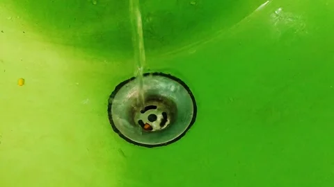 Vibrant green sink basin with a simple metallic drain fixture in a close-up view Stock Footage 324607297