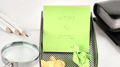 A vibrant green sticky note displays the words Failure versus Success in a Stock Footage 332837909