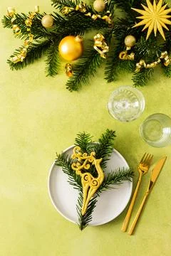 A vibrant green table setting for Christmas with an empty plate and cutlery.. Stock Photos