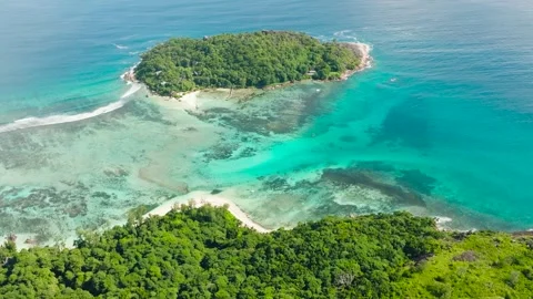 Vibrant greenery overlooking turquoise waters and coral reefs. Seychelles Stock Footage 304744477
