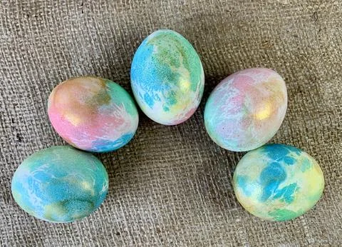 Vibrant, hand-painted Easter eggs are thoughtfully arranged in a circular Stock Photos