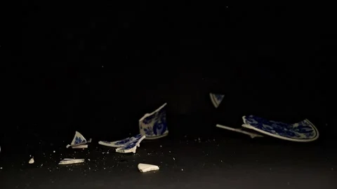 A vibrant hand-painted plate crashes to the ground, with shards scattering .. Stock Footage 300260876