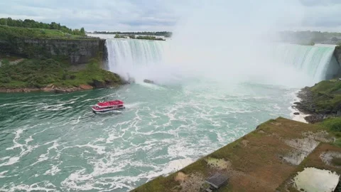 Vibrant image of Niagara Falls with red tourist boat navigating foamy waters Stockbeeldmateriaal 293493860