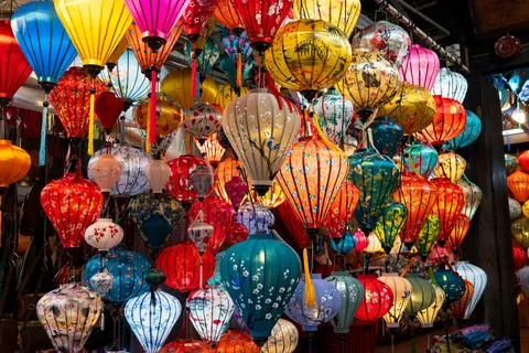 Vibrant, intricately patterned lanterns in assorted shapes and colors hang gr Stock Photos