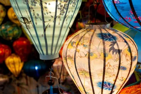 Vibrant, intricately patterned lanterns in assorted shapes and colors hang gr Stock Photos