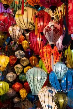 Vibrant, intricately patterned lanterns in assorted shapes and colors hang gr Stock Photos