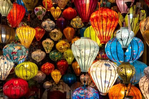 Vibrant, intricately patterned lanterns in assorted shapes and colors hang gr Stock Photos