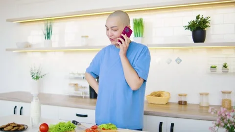 In a vibrant kitchen that is full of various decor elements, a bald woman who Stock Footage 293868683