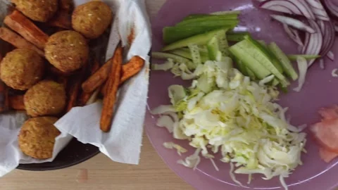 Vibrant kitchen setting featuring crispy falafel with fresh vegetables Stock Footage 323464504