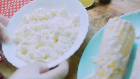 Vibrant kitchen study: pressing white cheese over a corn cob Stock Footage 342171843