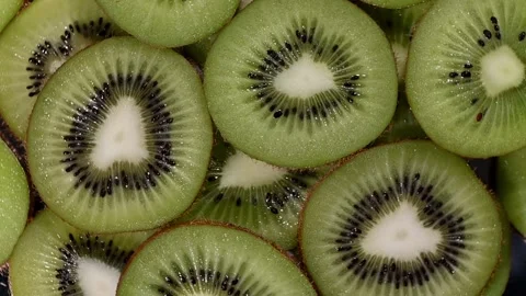 Vibrant Kiwi Slices Spin in Slow Motion. Top-Down Green Fruit Vortex Loop, 4K Stock Footage 324918809