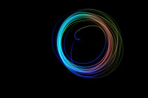 A vibrant light circle is captured in a dark setting, showcasing smooth curve Stock Photos