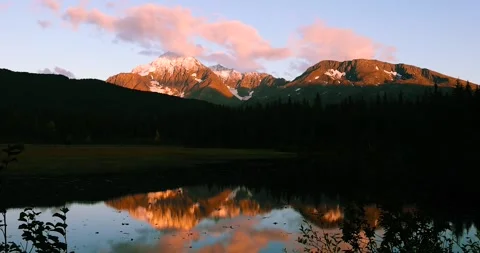 Vibrant lighting on the mountains of Alaskda during twilight, with reflecti.. Video stock 321559231