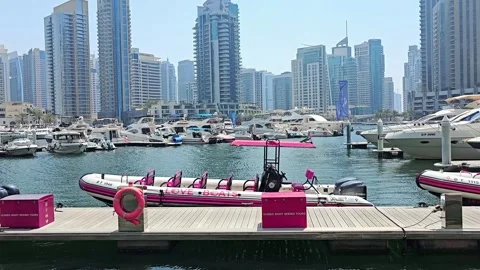 A vibrant marina in Dubai with boats docked, modern skyscrapers Stock Footage 311884953