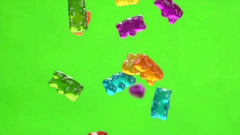 Vibrant multi-colored gummy bear candies falling through the air against a .. Video stock 327679108